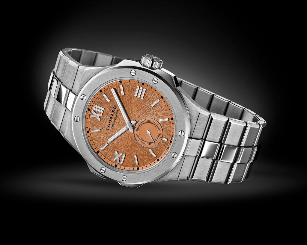 Steel sports watch wtih orange-hued patterned dial