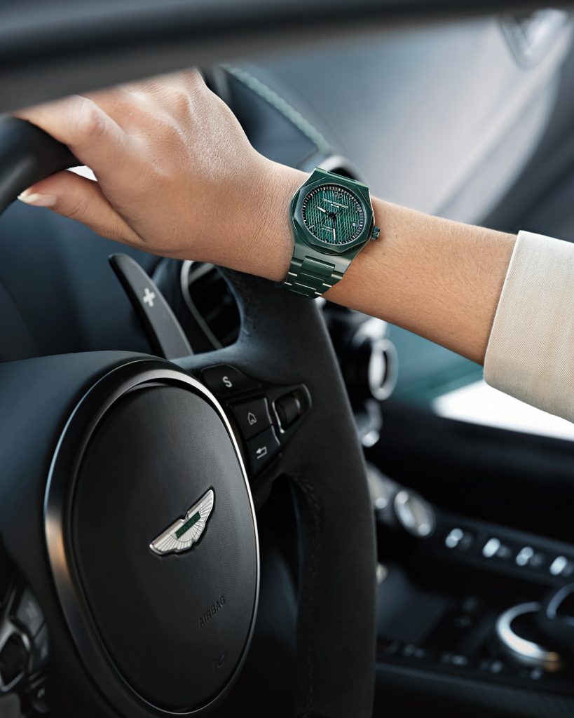 Green ceramic watch on a wrist on an Aston Martin steering wheel