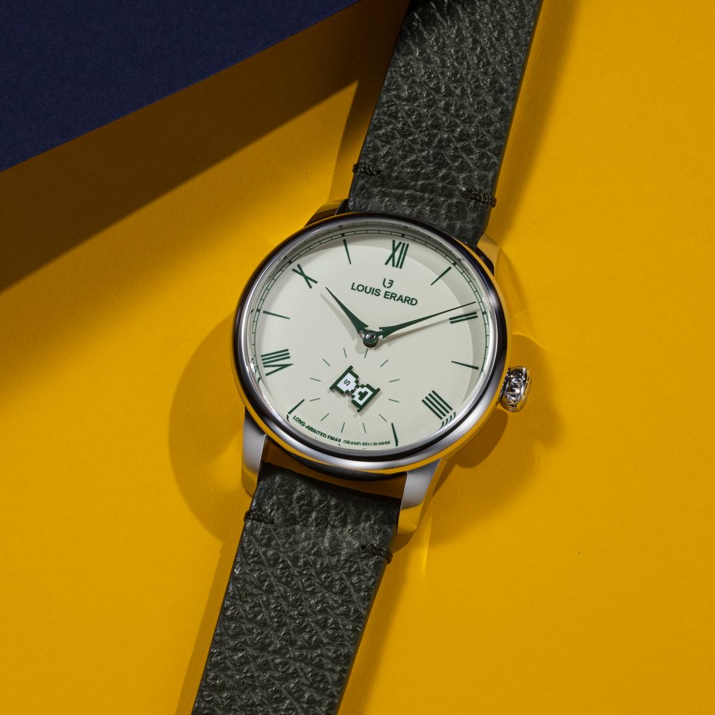 Stainless steel case watch with beige enamel dial and green hands and indices against yellow background