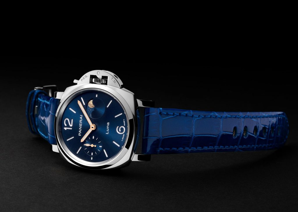 Steel case watch with blue dial and moon phase against black background