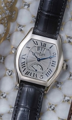 The Cartier Tortue features a silver-plated, solid gold dial with “2” and “5” in Arabic numerals.